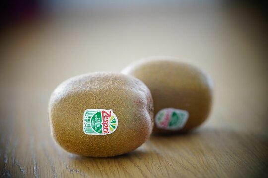 Zespri brand sticker with logo on a kiwi fruit on a table