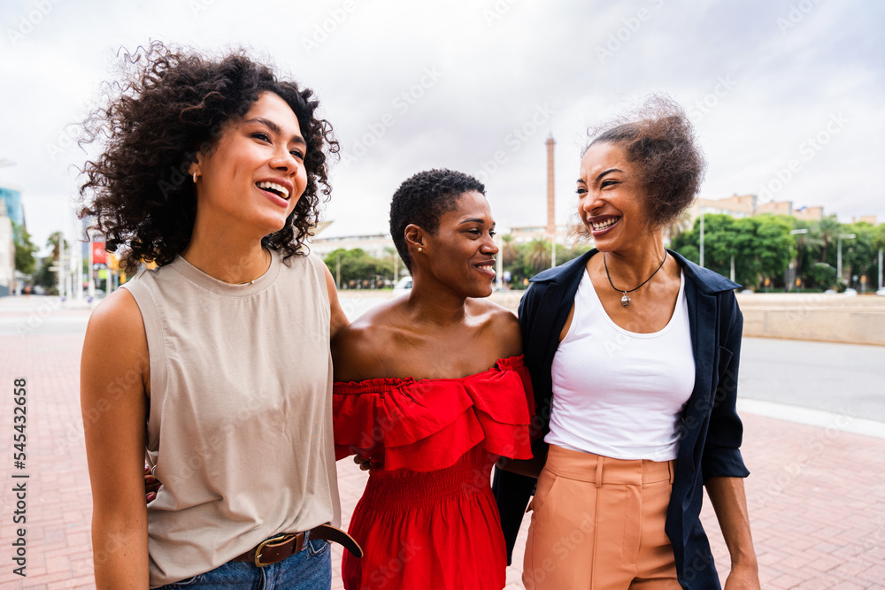 Wall mural three mixed race hispanic and black women bonding outdoors