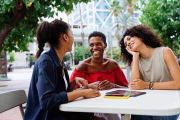 Three mixed race hispanic and black women bonding outdoors