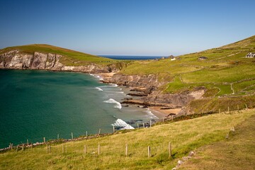 Grassy green cliff near the ocean on a sunny day