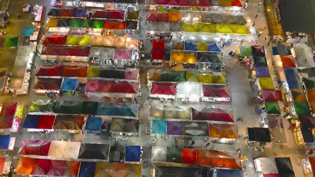 Aerial top view of Night Market people walking street, Colorful tents in the train of Ratchada at Bangkok city, Thailand. Retail shops