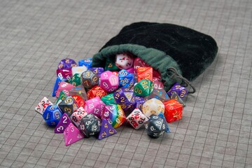 A pile of gaming dice coming out of a black bag