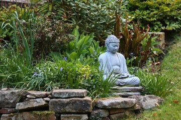 Scenery of a park with sitting stone Buddha statue in Yorkshire village, United Kingdom