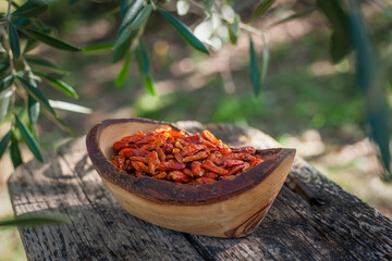 Hot spicy chili pepers. Close up of dried red dry chili pepers in a wooden bowl. Hot chili pepers...