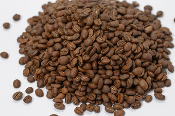 A pile of coffee beans on a white background, place for advertising.