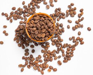 Scattered coffee beans on a white photo and a mug with coffee beans.