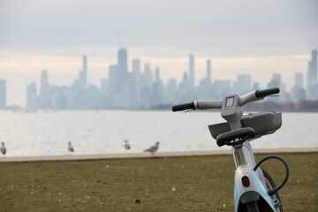 Closeup shot of a Divvy bike on a grass field with the Chicago cityscape in the background