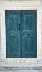 Vertical shot of a blue door in a white building in Lopud, Croatia