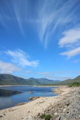 Sunny day at the beach with a cloudy blue sky