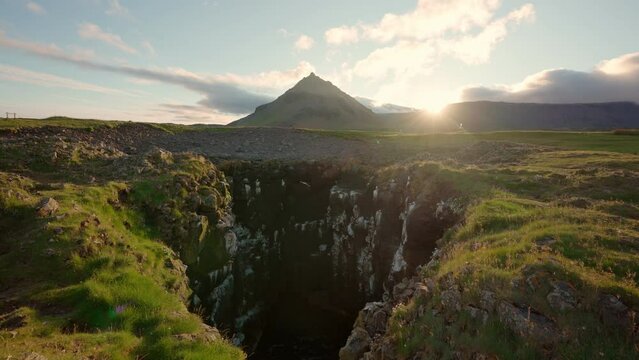Sunset over Stapafell mountain and seagull nest hole on coastline in Arnarstapi village on summer at Iceland