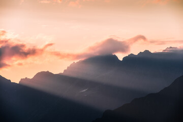 Light rays and mountain peaks during sunset in the Orobie Alps, Northern Italy