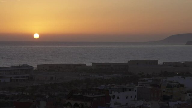 Sun slowly setting down on the sea in Tamraght, Morocco
