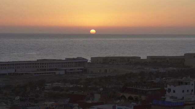 Sun slowly setting down on the sea in Tamraght, Morocco