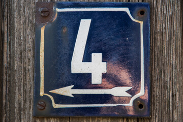 Weathered grunge square metal enameled plate of number of street address with number 4