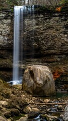 Vertical light exposure shot of hemlock falls flowing atop rocks