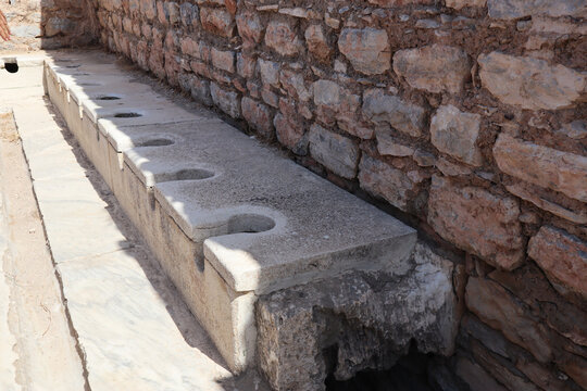 Ancient public Toilet bathroom seats on Ephesus made of rocks, bricks, granite and marble