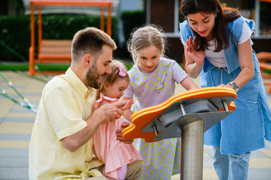 Family play at interactive game at playground