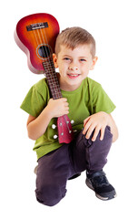 Cute boy playing the ukulele guitar isolated on white background - 545457449