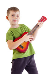 Cute boy playing the ukulele guitar isolated on white background - 545457451