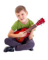 Cute boy playing the ukulele guitar isolated on white background - 545457469