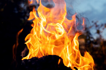 Bonfire in the evening against the background of the blue sky