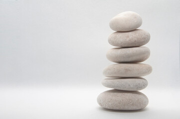 Obraz na płótnie Canvas Zen stones stacking on white background with customizable space for text or ideas. Copy space.
