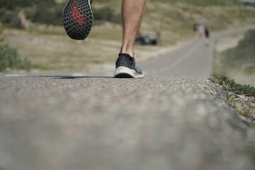 A man is jogging on a street between dunes