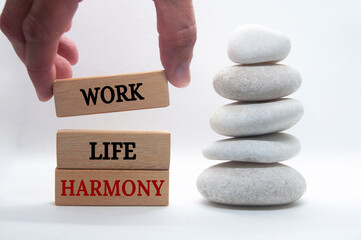 Work life harmony text on wooden blocks with zen stones background. Business working culture...