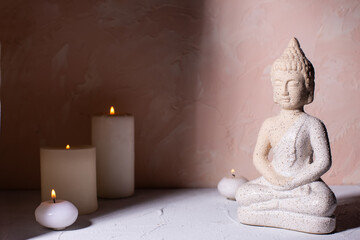 Wellness concept with statue of Buddha  and with burning candles for spa time.  Religion concept.