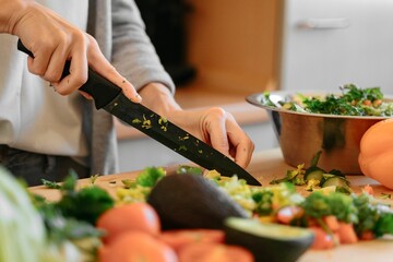 Closeup shot of a female cutting vegetables