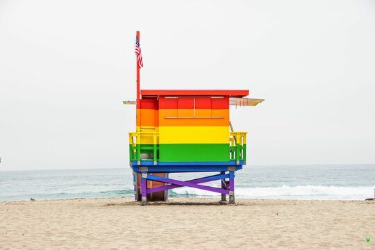 Lifeguard tower painted in rainbow colors in honor of LGBT Pride and pier in the background.