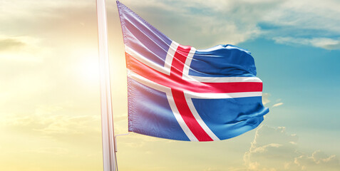 Waving Flag of Iceland in Blue Sky. The symbol of the state on wavy cotton fabric.