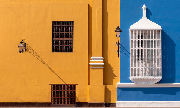 Traditional style architecture with blue and yellow wall and delicate windows railings, Trujillo, Peru