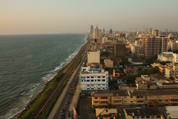 Drone shot of cityscape buildings by the sea at sunset in  Colombo, Sri Lanka