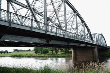 Rustic metal bridge over the river, partial view close-up