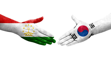 Handshake between Tajikistan and South Korea flags painted on hands, isolated transparent image.