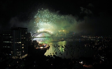 Sydney, New South Wales, Australia: Fireworks over Sydney Harbour to celebrate the New Year. Firework display with bridge, city and harbor.