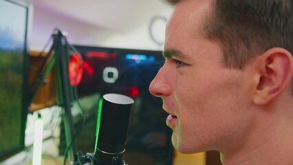 Male gamer at home sitting in front of multiple monitors live streaming shooting game online - shot in slow motion