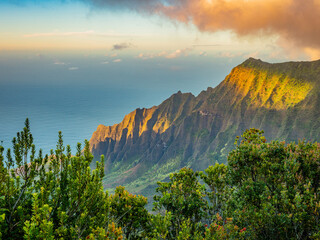 Sunset. Blue sky over green mountains. Amazing view of the ocean. Pu'u o Kila Lookout, Kauai, Hawaii