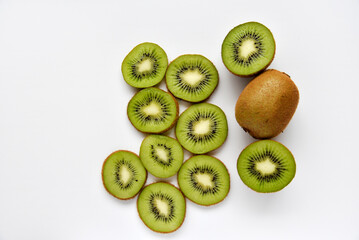 Naklejka na ściany i meble Chopped fruit of green juicy kiwi on a white background. Delicious kiwi slices close-up.