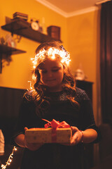 Little girl holding Christmas tree lights in her head