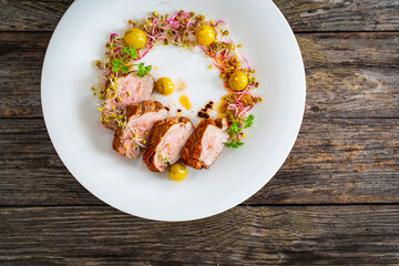 Fried pork loin with fresh vegetables on wooden table
