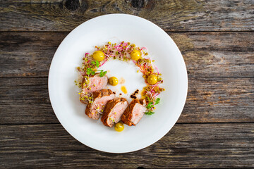 Fried pork loin with fresh vegetables on wooden table
