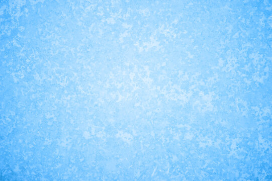 The blue texture of ice in the glow of a pattern of white frost. Background concept