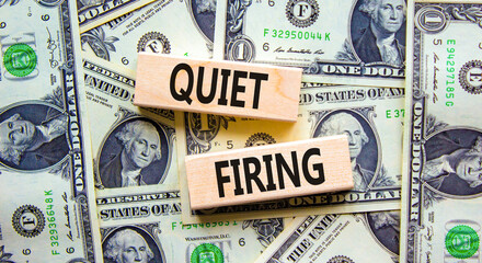 Quiet firing symbol. Concept words Quiet firing on wooden blocks. Beautiful background from dollar bills. Business and quiet firing concept. Copy space.