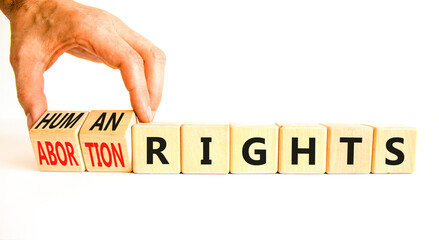 Abortion rights symbol. Concept words Abortion rights are human rights on wooden cubes. Businessman hand. Beautiful white table white background. Business medical abortion rights concept. Copy space.