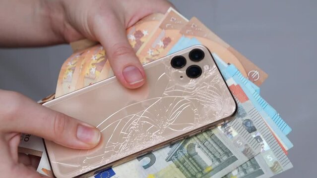 Minsk, Belarus - November 12, 2022: Golden iPhone 11 phone. Crack on the back of the iPhone phone. phone repair concept, broken phone, phone repair money