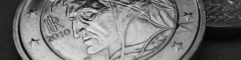 Euro coins closeup. 2 euro coin lies on dark surface. Coin issued in Italy. Obverse depicting Dante Alighieri. Black and white banner or headline about European Union currency. EU economy news. Macro