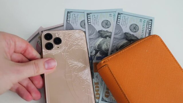 Minsk, Belarus - November 12, 2022: Golden iPhone 11 phone. Crack on the back of the iPhone phone. phone repair concept, broken phone,   repair money