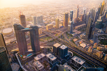 Fototapeta na wymiar Dubai city view at sunset, Sheik Zayed Road main junction with cars and tube line